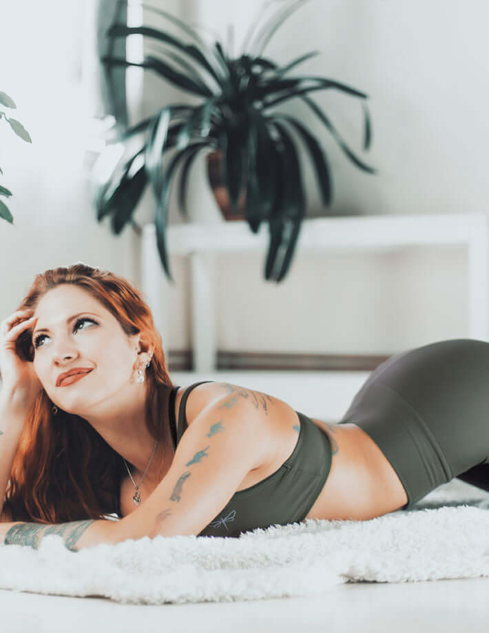 Woman in mid rise leggings practicing yoga in a bright room, showcasing the comfort and style of Mid rise leggings.
